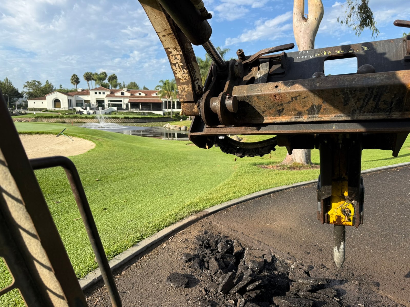 Precision concrete, asphalt demo and hauling at The Country Club of Rancho Bernardo using an industrial wet-cut saw for pre-cutting, a Bobcat skid steer with a hydraulic breaker for structural breakout, and heavy dump trailers for debris removal.